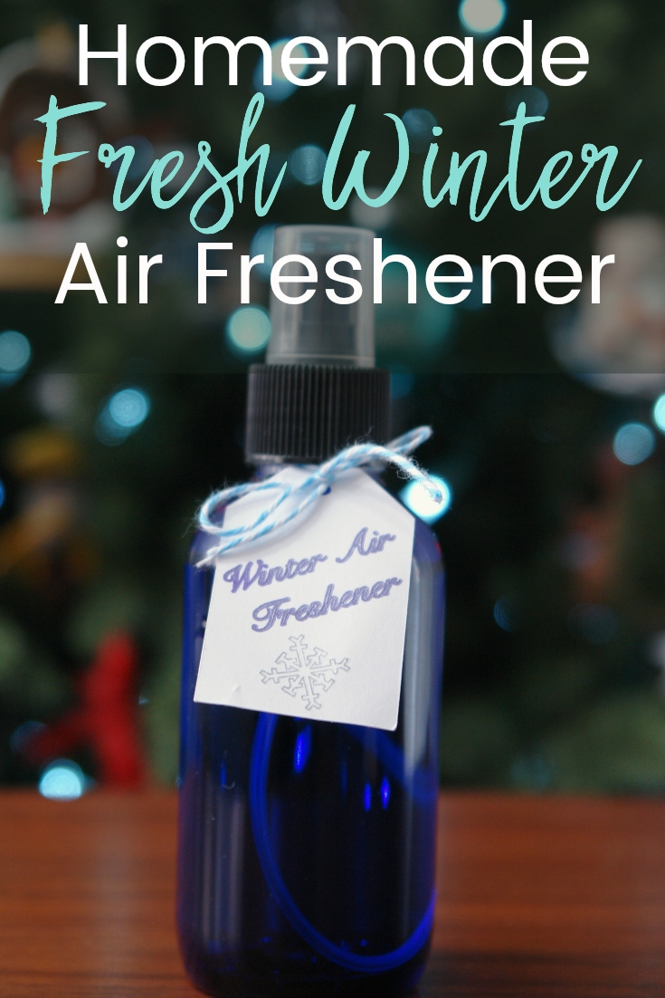 Fresh winter air freshener in blue spray bottle with tag sitting on table