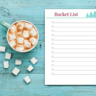 Cup of hot cocoa or chocolate with marshmallow and notebook with to do list on turquoise vintage table from above, christmas planning concept. Flat lay style.