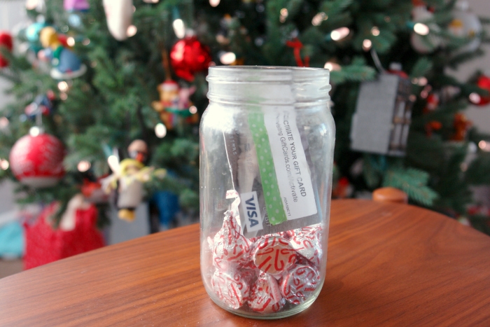 gift card in jar with a little bit of candy in front of Christmas tree