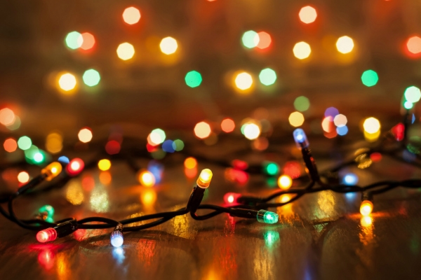 Christmas multicolored lights on a wooden background