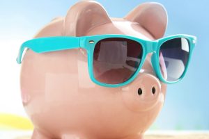Piggy bank with sunglasses on the beach