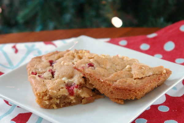 cranberry white chocolate blondies on plate in front of christmas tree