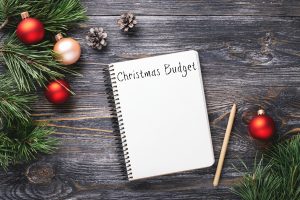 budget notebook and Christmas decorations on wooden table