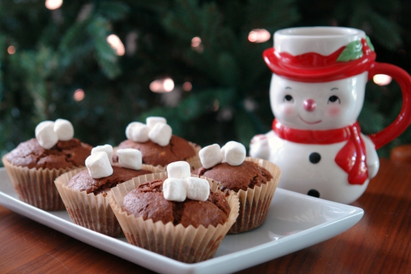 hot chocolate muffins and a snowman mug in front of Christmas tree