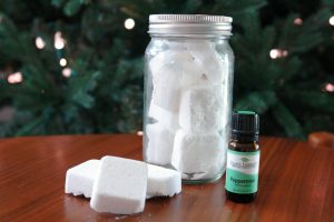shower steamers in jar on table with bottle of essential oils
