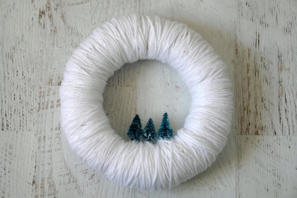 white christmas wreath with small christmas trees