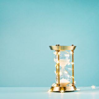 Hourglass wrapped in lights on a blue background