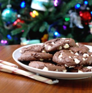 double chocolate peppermint cookies on white plate on table in front of Christmas tree