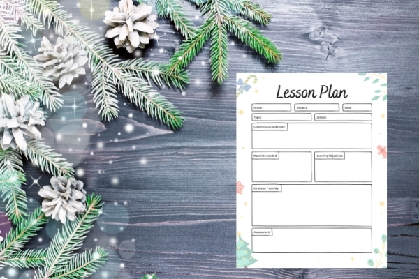 christmas lesson plan on gray wooden table with evergreen pieces on table