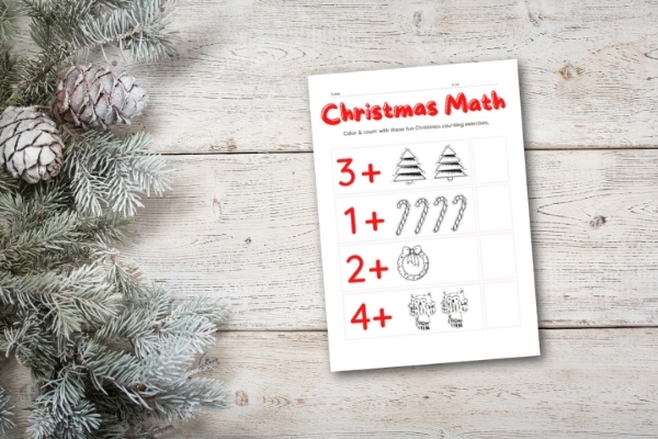 christmas math workbook on white table with evergreen pieces