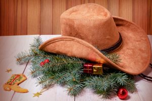 Cowboy western hat and Christmas decoration on wood background