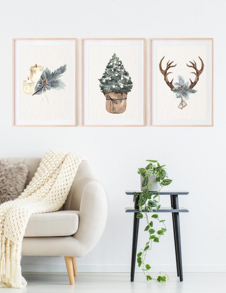 three framed Christmas wall art prints in living room by sofa