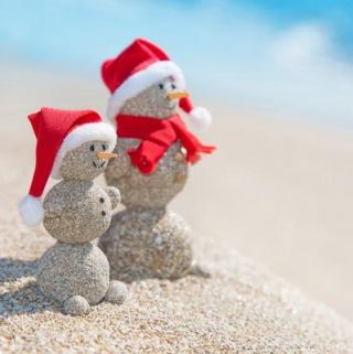 snowman couple made out of sand on beach