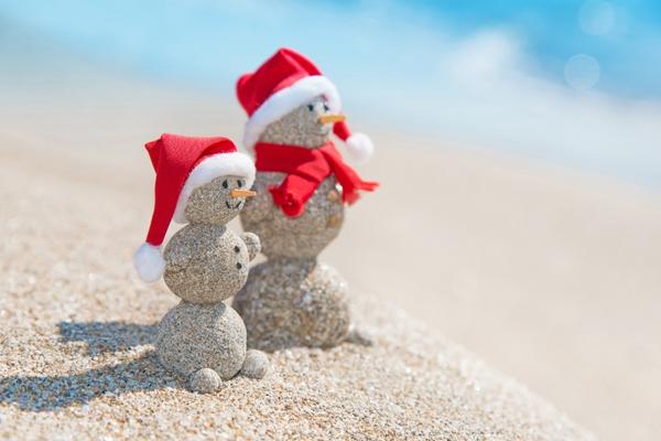 snowman couple made out of sand on beach