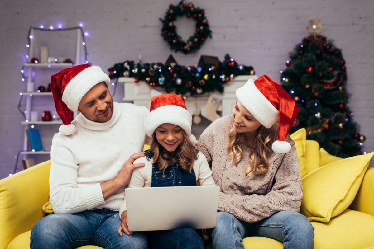 family wearing Santa hats looking at laptop