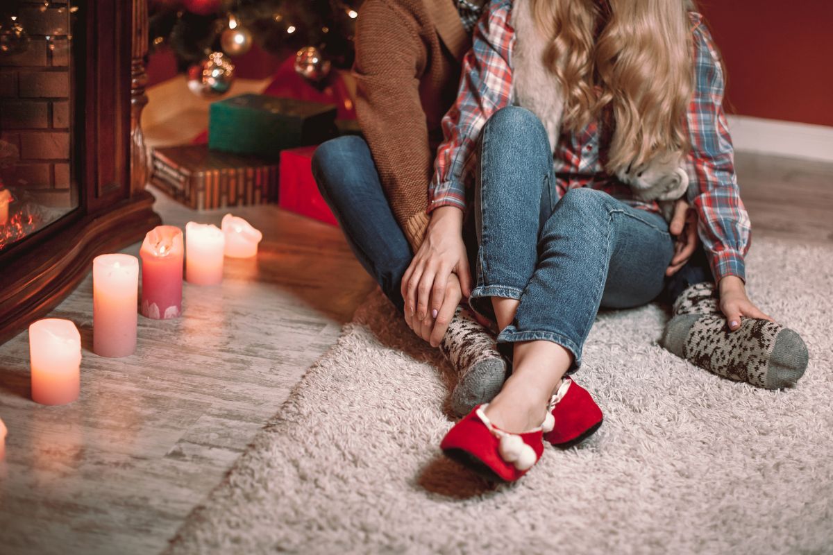 couple sitting on floor with christmas tree in background 